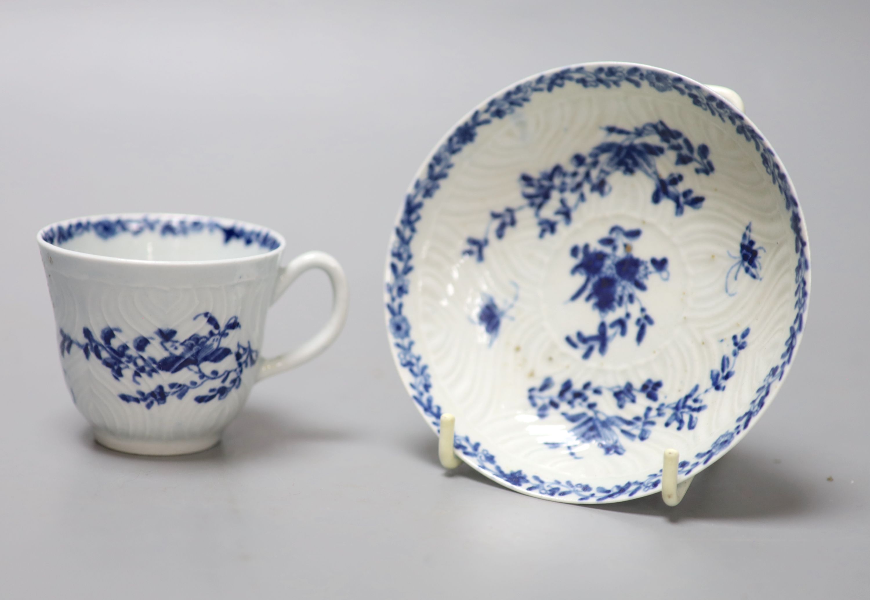 An 18th century Worcester feather mould floral coffee cup and saucer, workmans marks, diameter 11.5cm